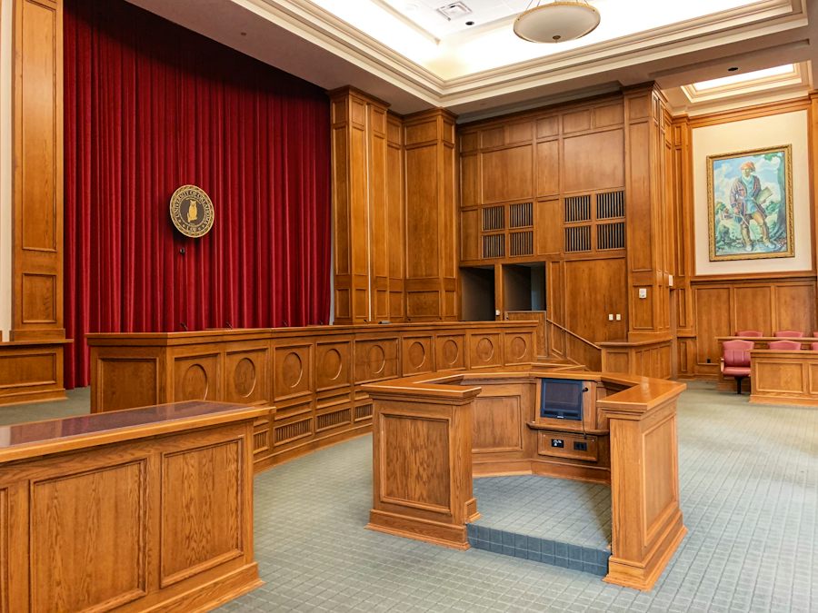 Wood-panelled courtroom with the judge's bench and counsel tables